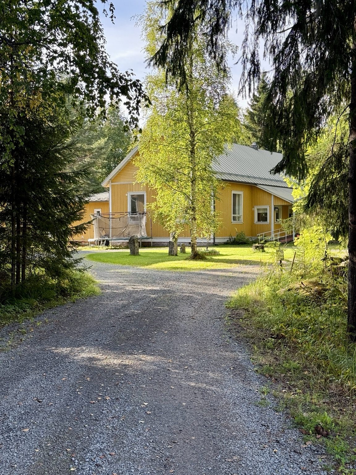 Valkealuomen koulurakennus kesäisessä pihapiirissä